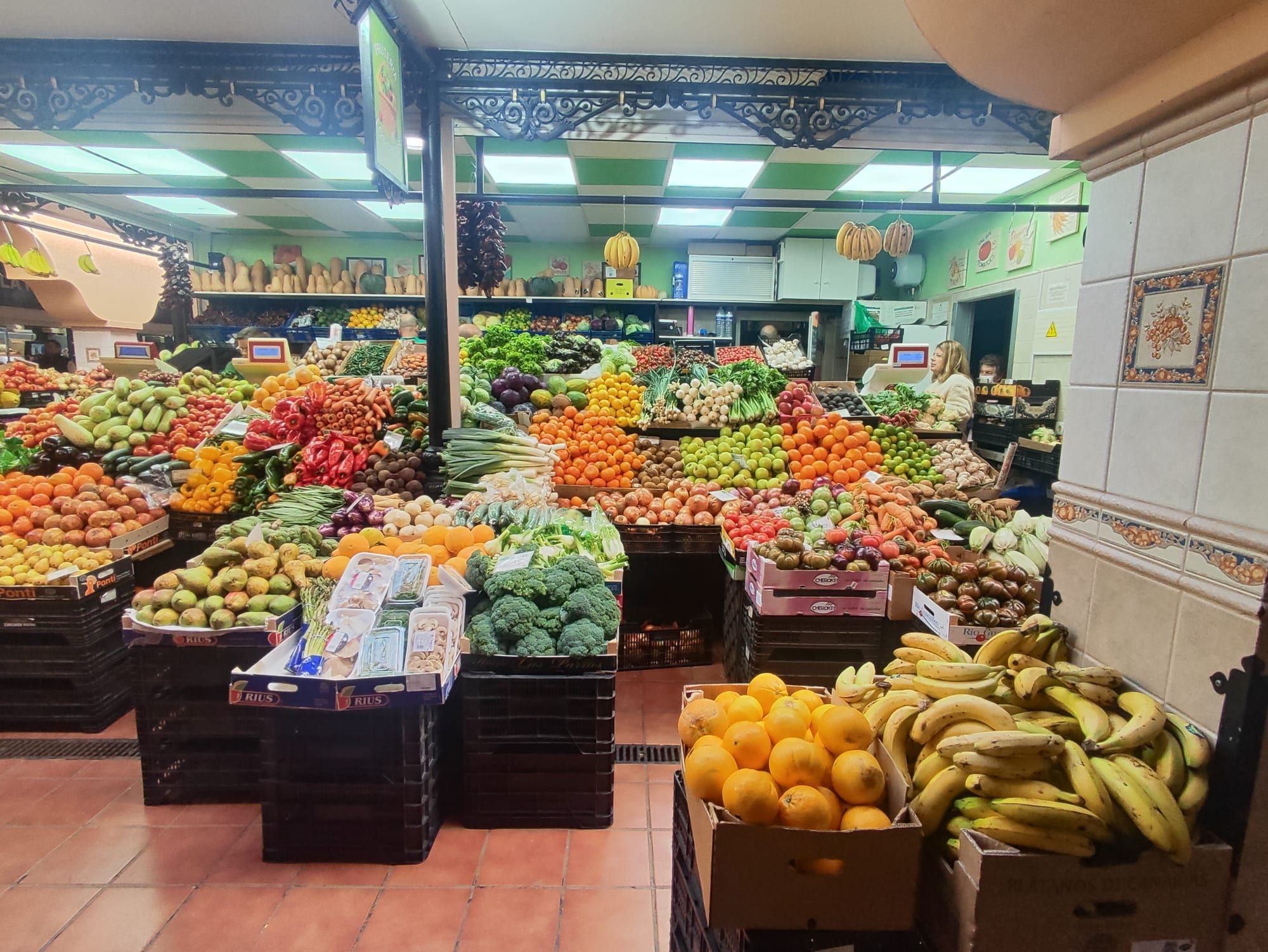 A fruit and vegetable stall piled with bananas, oranges, broccoli and peppers inside the Mercado de Nuestra Señora de África in Santa Cruz de Tenerife